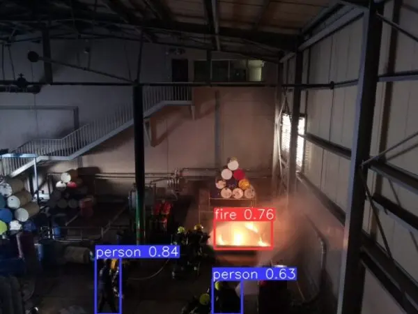 Detection overlay labelling a flame and two people in a warehouse